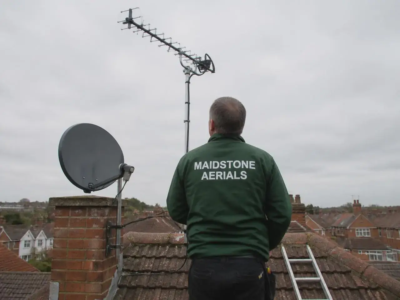 Maidstone Aerials engineer aligning a satellite dish on a Folkestone clifftop property